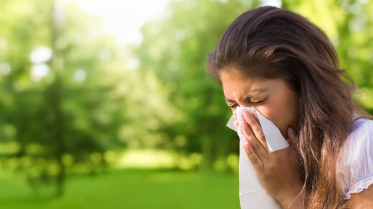 woman outdoors with allergies that cause tinnitus