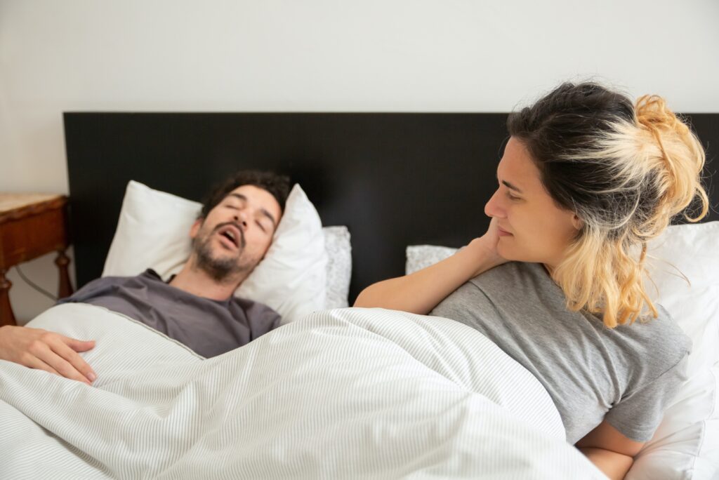 Man snoring in bed