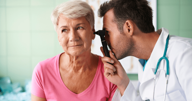 Doctor looking inside of a woman's ear