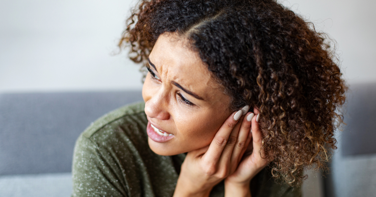 Woman holding her ear in pain