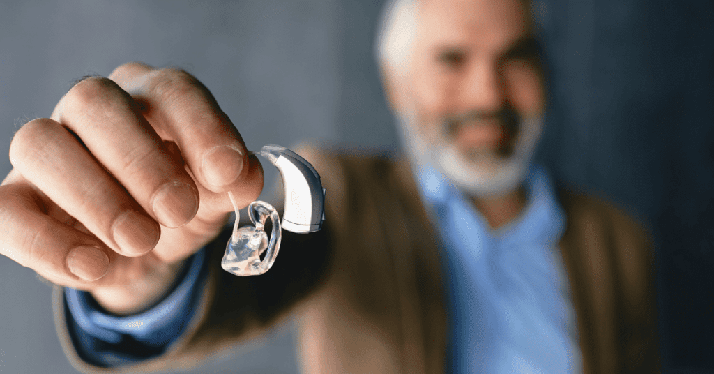 Man holding a tinnitus masker in his hand