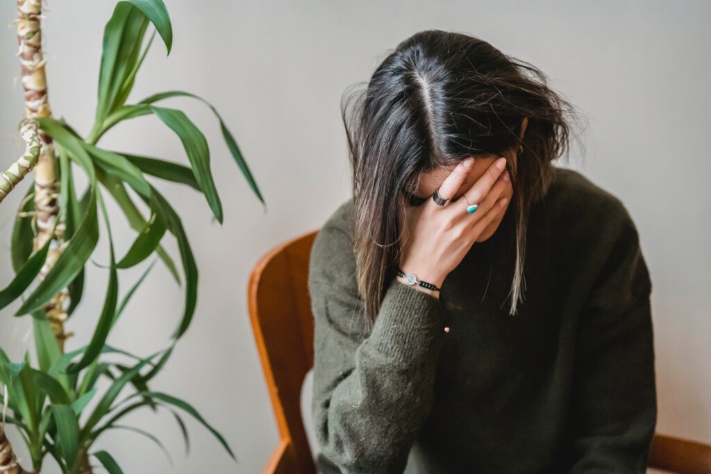 Woman sitting in a chair with her head in her hand