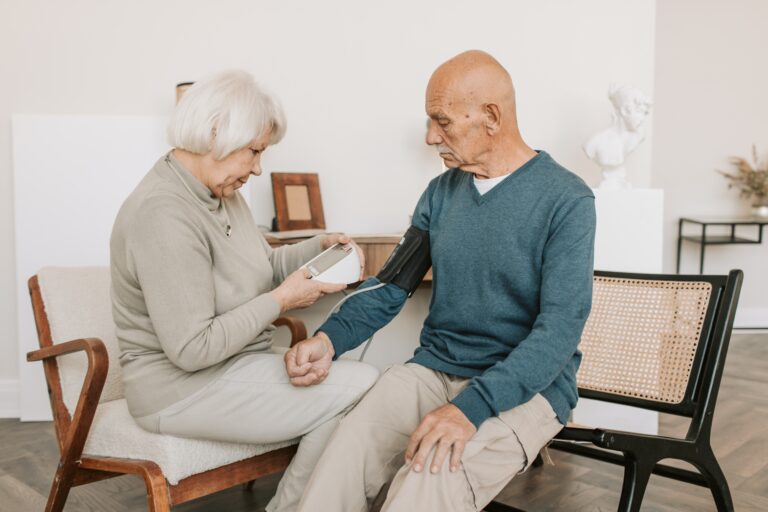 Woman taking man's blood pressure