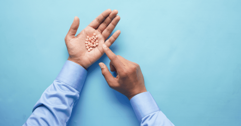 Hand holding tan pills