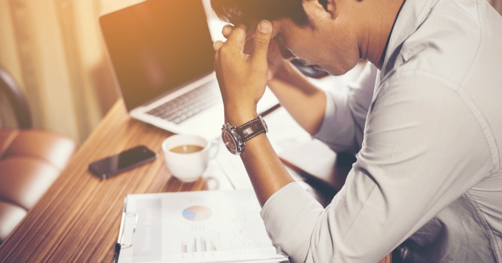 Man sitting at a desk struggling to concentrate