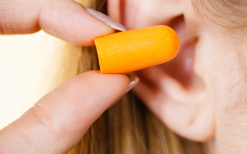 Person putting in foam earplugs