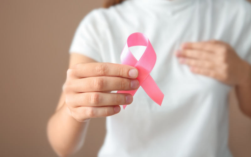 Woman holding a pink ribbon for breast cancer awareness