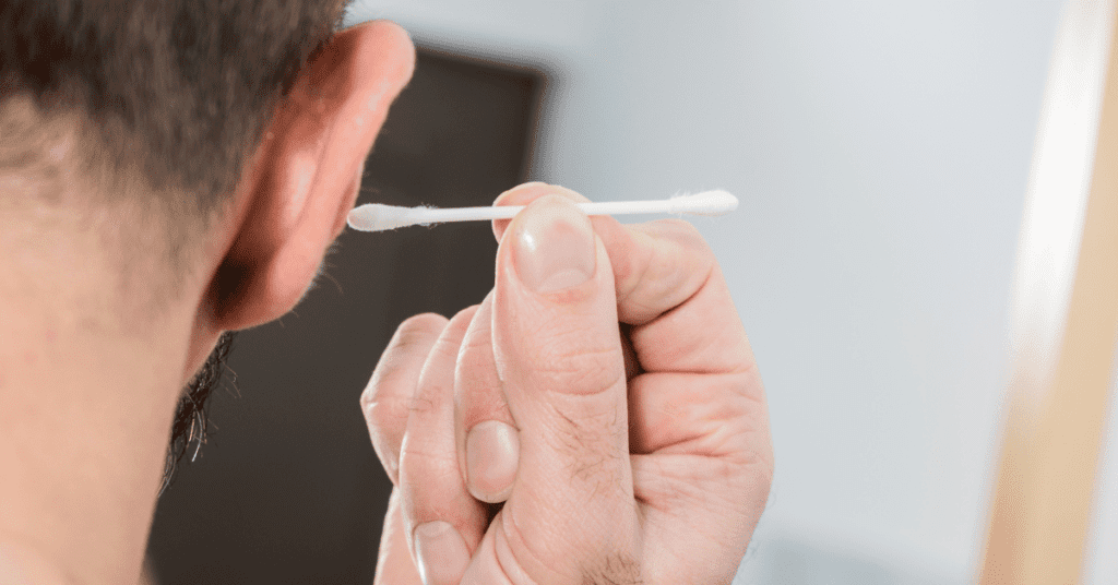 Man putting a Q-Tip into his ear