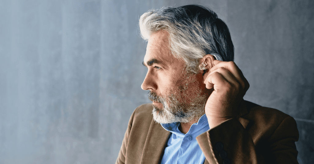 Man putting on a hearing aid