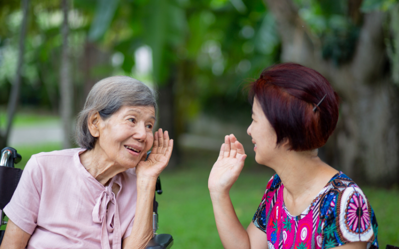 Woman with hearing loss struggling to hear her friend speak