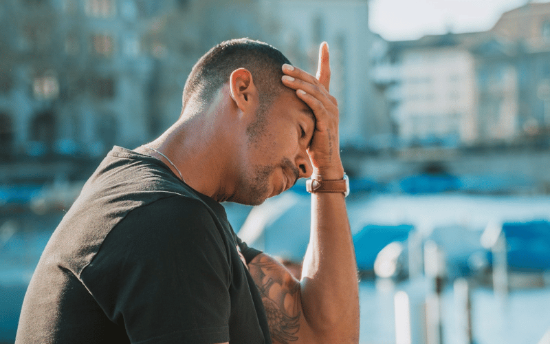 A stressed man holding his head in his hands