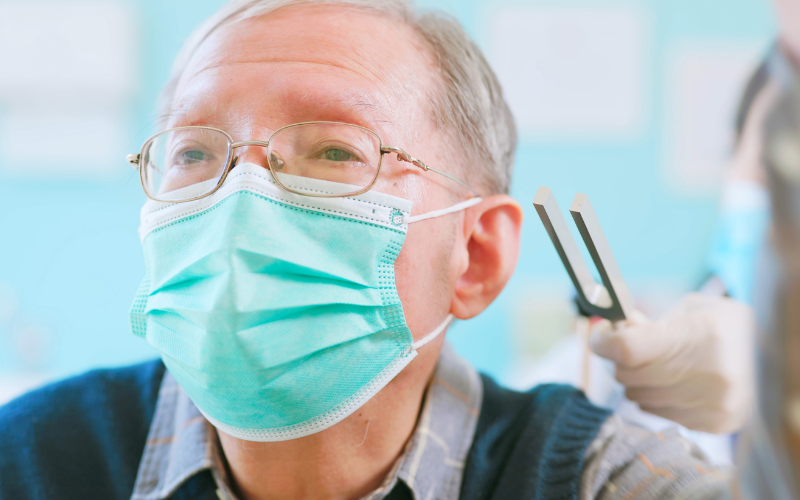 Man getting a tuning fork test as part of an audiological exam