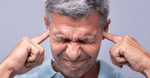 Man holding his fingers in his ears to block out soud