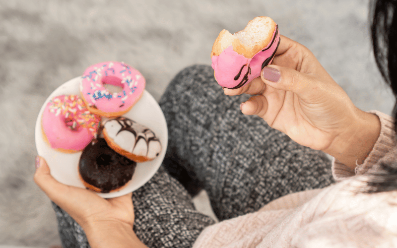 Person eating a plate of donuts