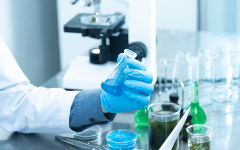 Scientist examining different beakers in a lab