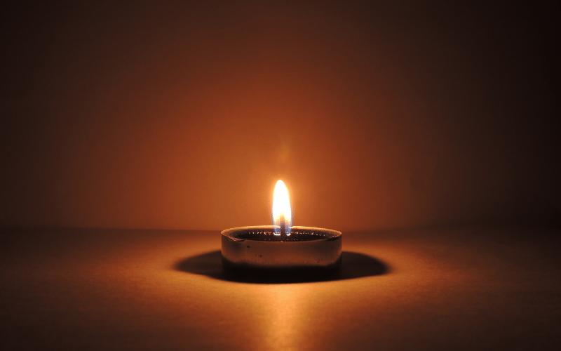 Candle burning in a dark room