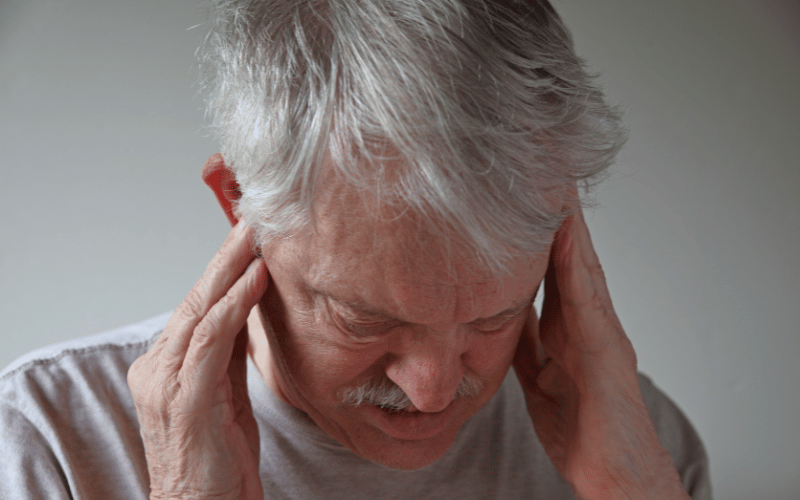 Man with vertigo holding his head