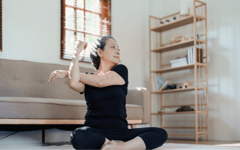 Woman sitting on the floor and stretching 