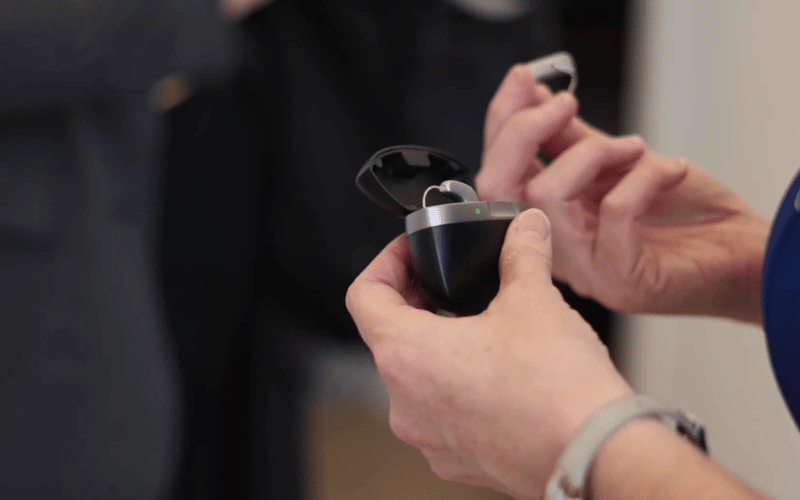 Person taking their sound therapy devices out of their charging case