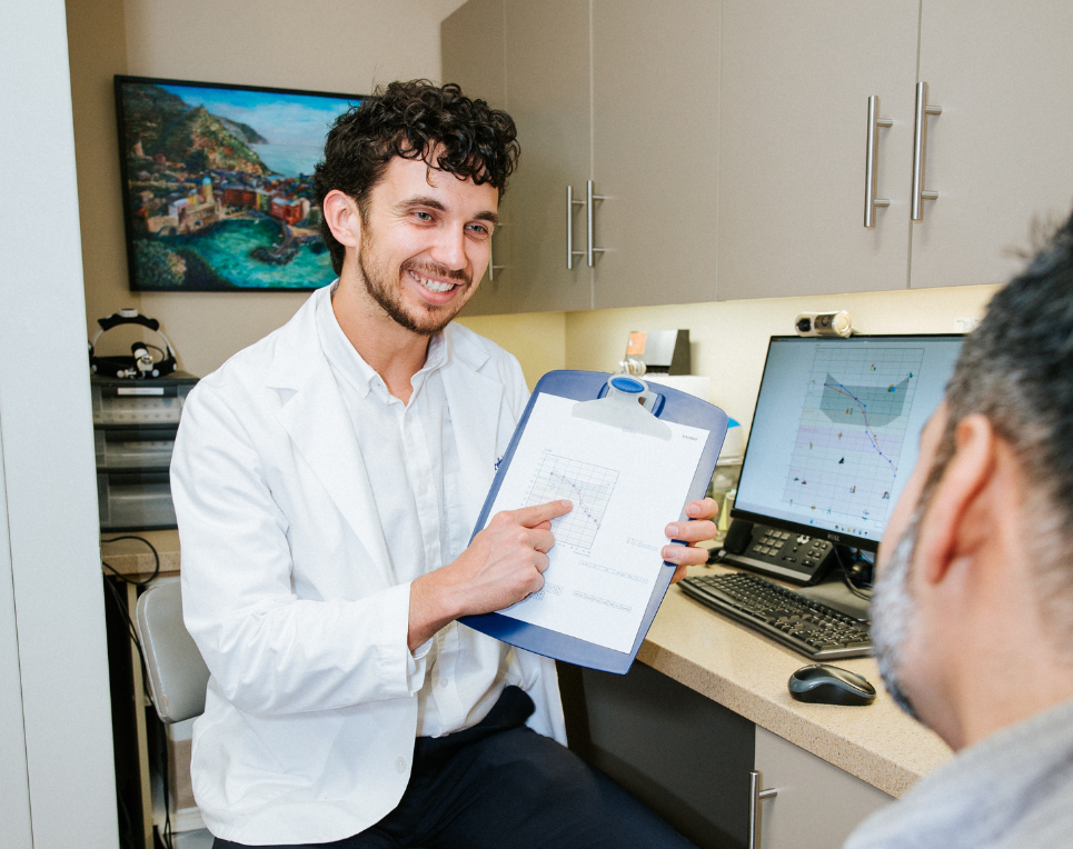 Dr. Ben Thompson explaining audiogram results to a patient during a tinnitus treatment consultation at Treble Health San Francisco.